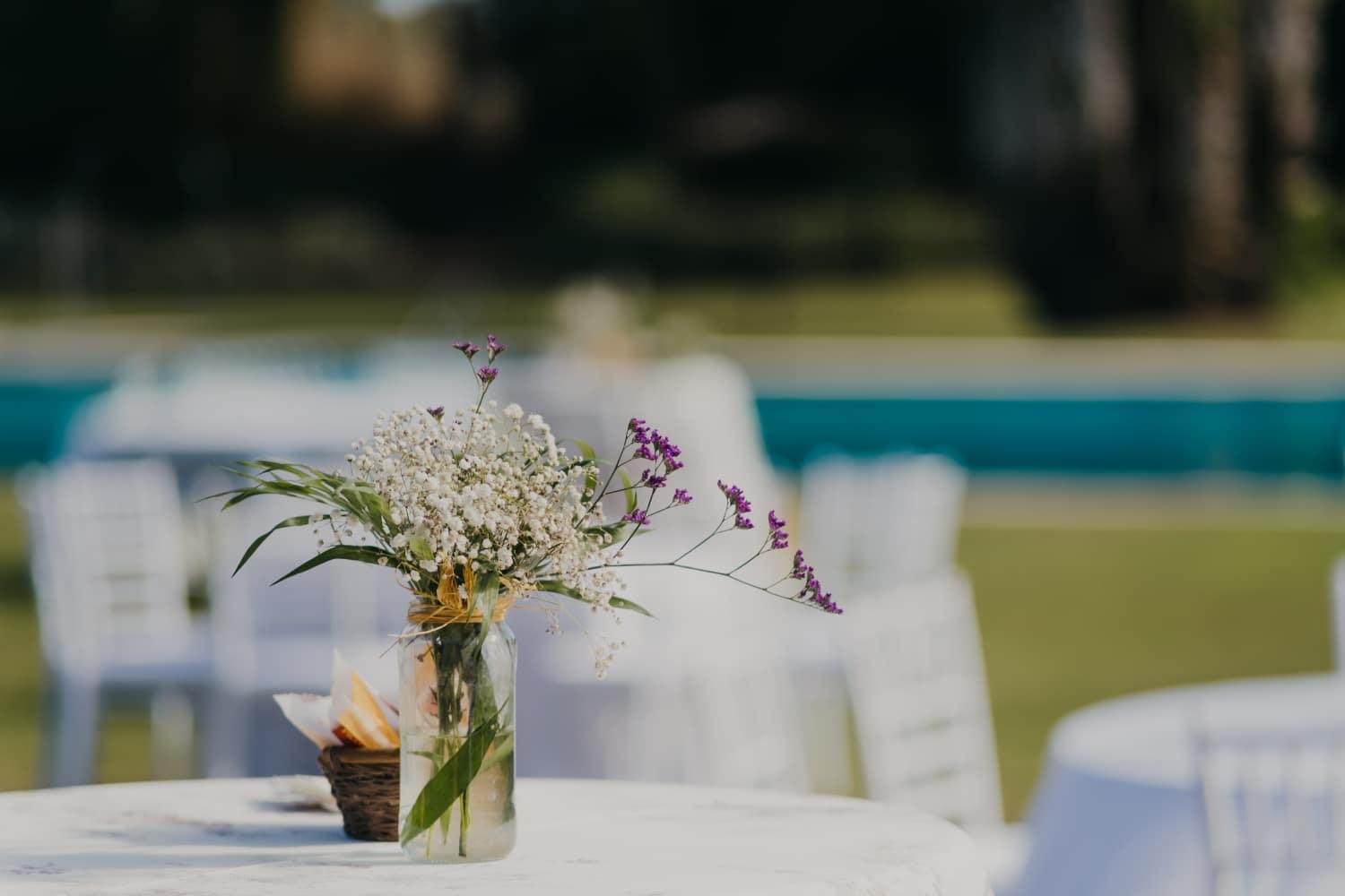 Banquete de boda con las mesas altas de aperitivo y decorada con un jarrón de flores