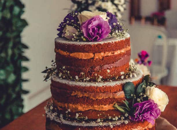 tarta de boda de estilo nake, sin recubrimiento y con flores