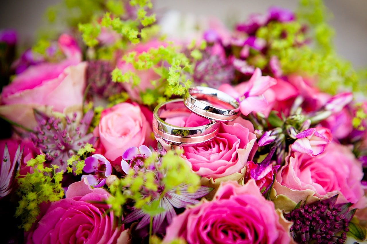 anillos de boda encima de un ramo de novia