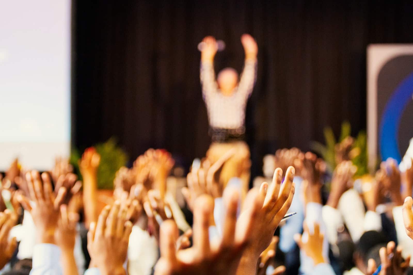 Gente levantando las manos con la Planificación de eventos corporativos