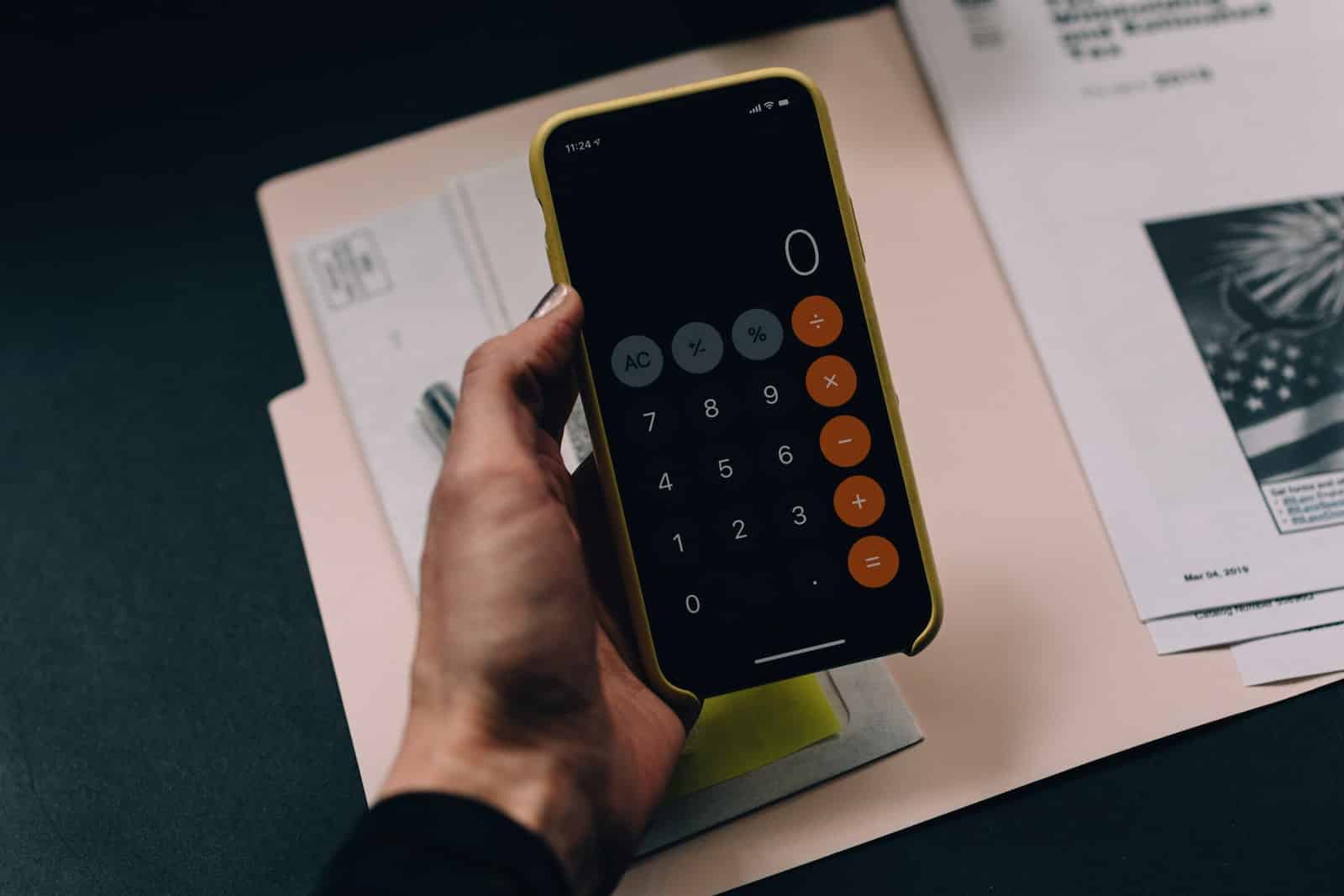 persona haciendo un presupuesto con la calculadora de un iphone
