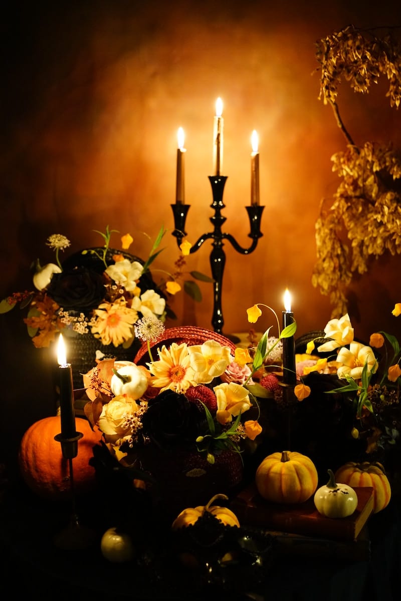 decoración de halloween con velas, flores y calabazas