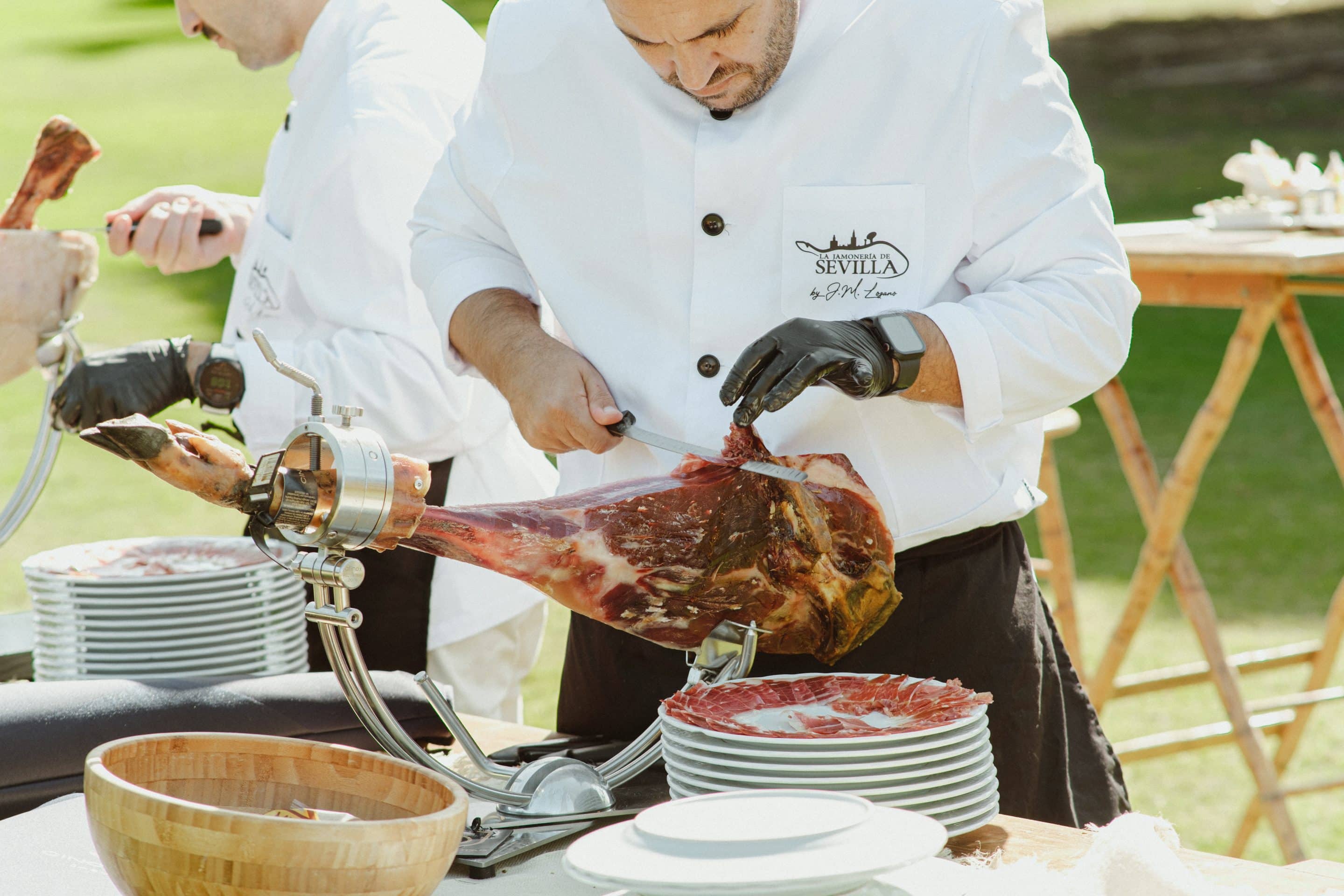 jamonero cortando jamon a cuchillo en una mesa de chacina